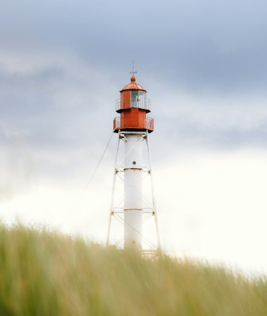 Das Bild zeigt einen Leuchtturm auf einer Düne
